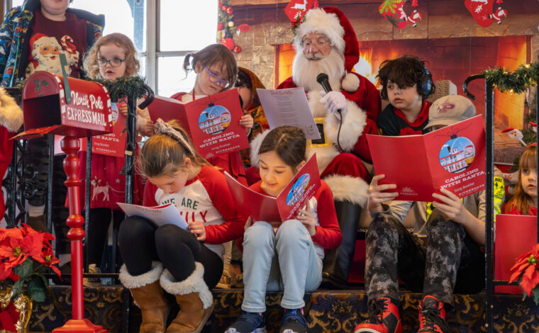 Children sit around Santa as they all sing Christmas songs during a Caroling with Santa Cruise on the Riverboats at the Gateway Arch