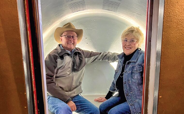 A couple sit in a spacious pod as part of the Tram Ride to the Top of the Gateway Arch.