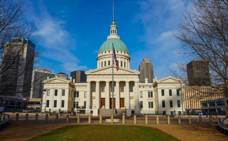 Image of the Old Courthouse's east-facing entrance from across the street on a blue sky day